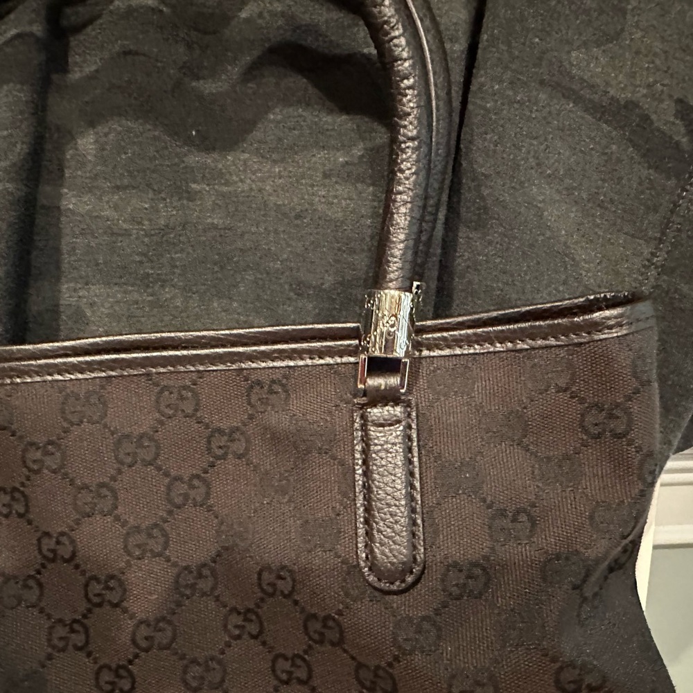 Brown canvas Gucci shoulder bag with silver detail on the strap.